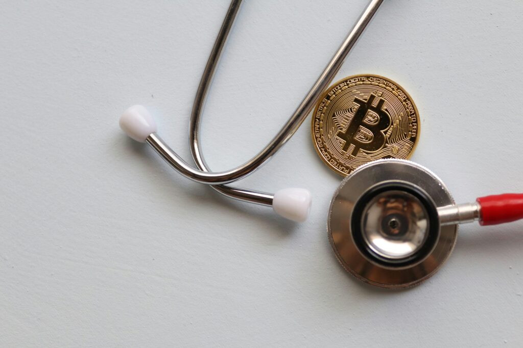 A stethoscope with a Bitcoin coin symbolizing the intersection of healthcare and cryptocurrency.