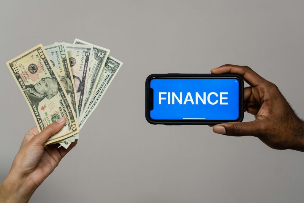 pexels-photo-6694482-6694482 Image depicting currency and finance concept with hands holding cash and a smartphone.