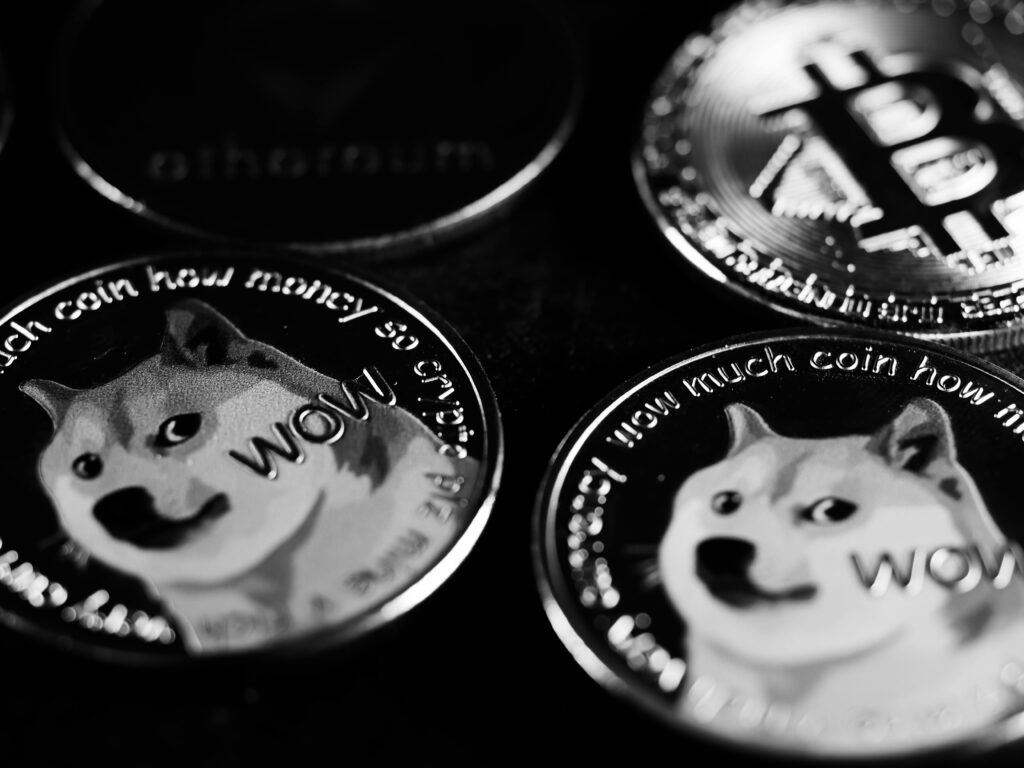 pexels-photo-7767493-7767493 Monochrome image focusing on physical Dogecoin and Bitcoin coins, highlighting cryptocurrency.