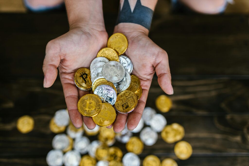 pexels-photo-8370749-8370749 High angle of hands holding gold and silver cryptocurrency coins, symbolizing digital wealth.
