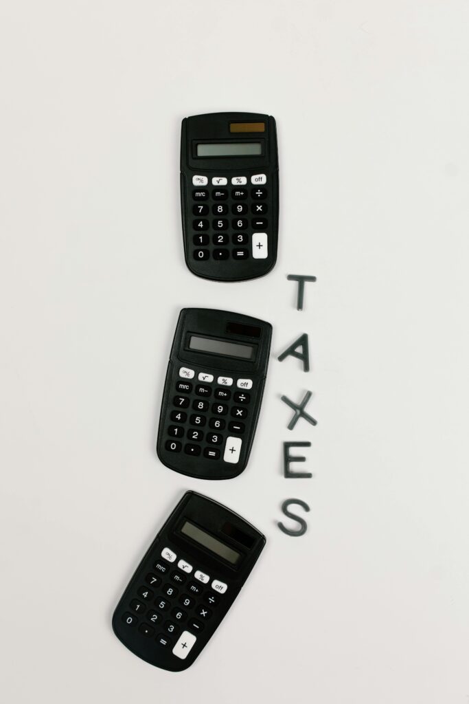 Flat lay of three calculators with 'TAXES' text on a white background.